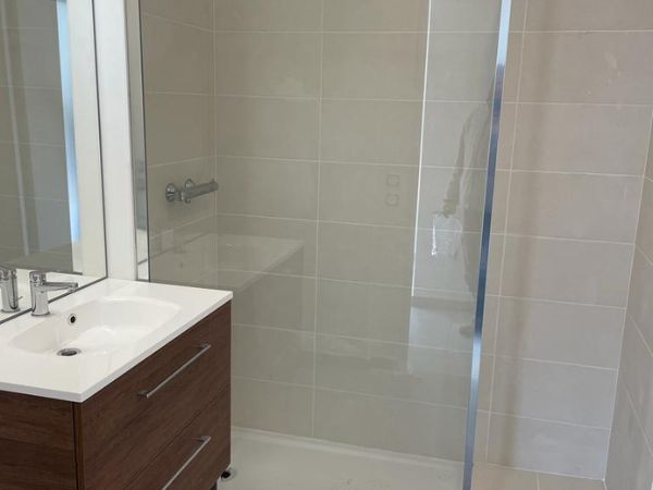 Rénovation de salle de bains avec douche et robinetterie élégante par un artisan 24/7.